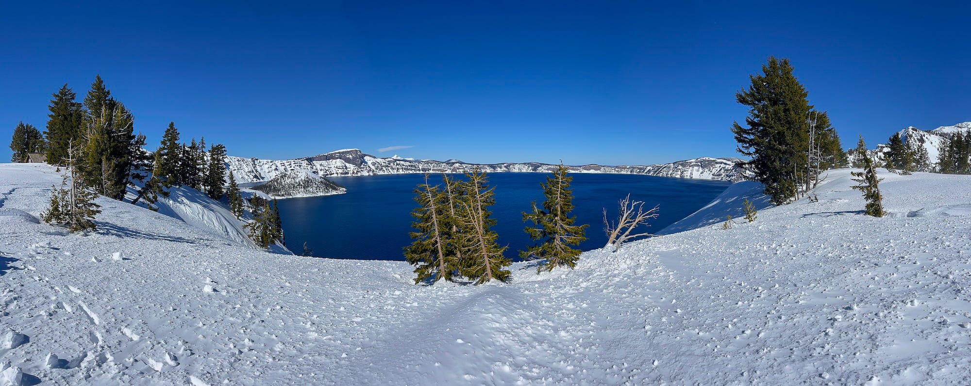 Crater Lake in March from the snowy rim, deep blue water below a ring of white cliffs