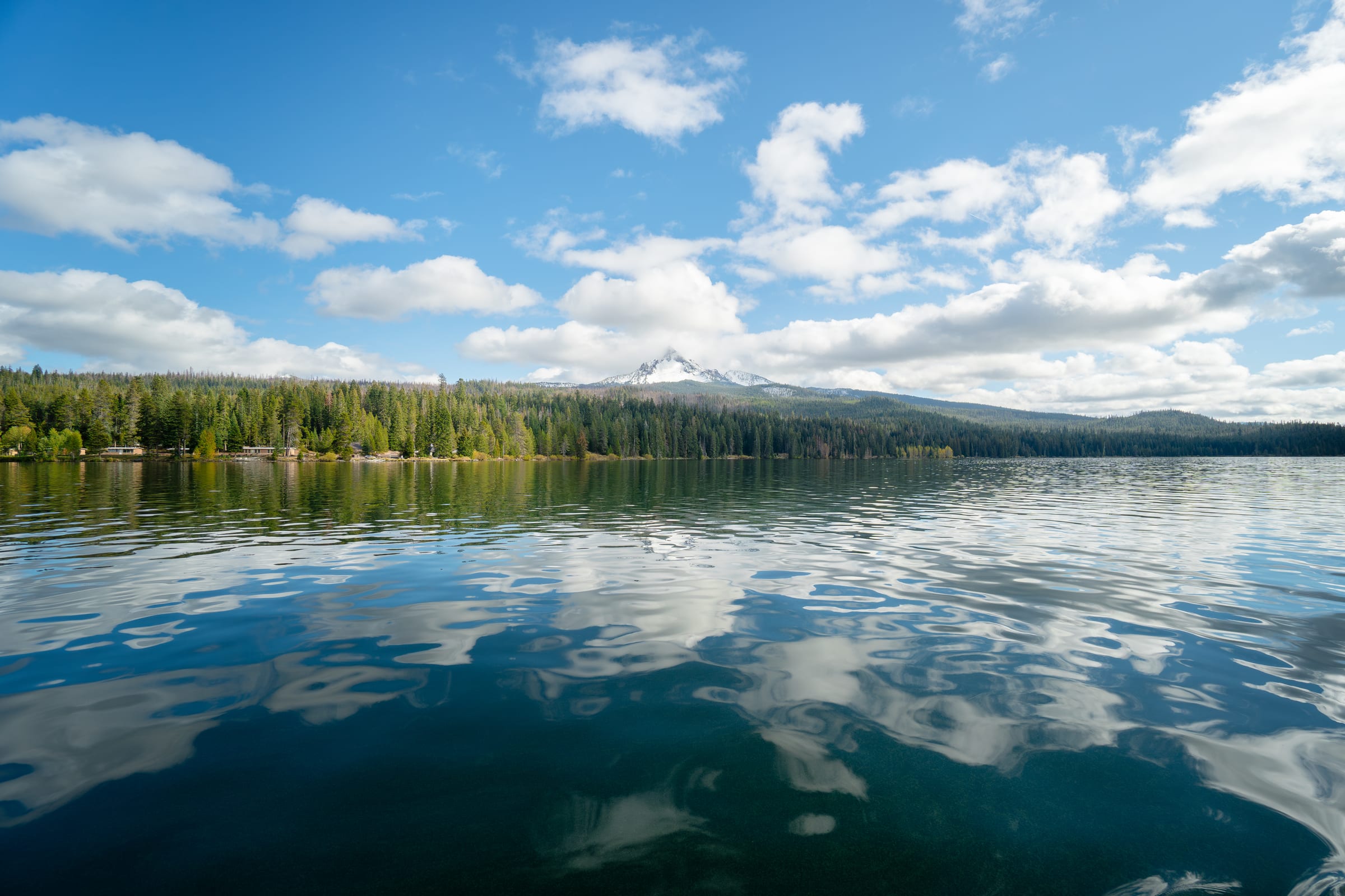 Diamond Lake in October, clouds reflected on the water and a snowy peak above the far shore