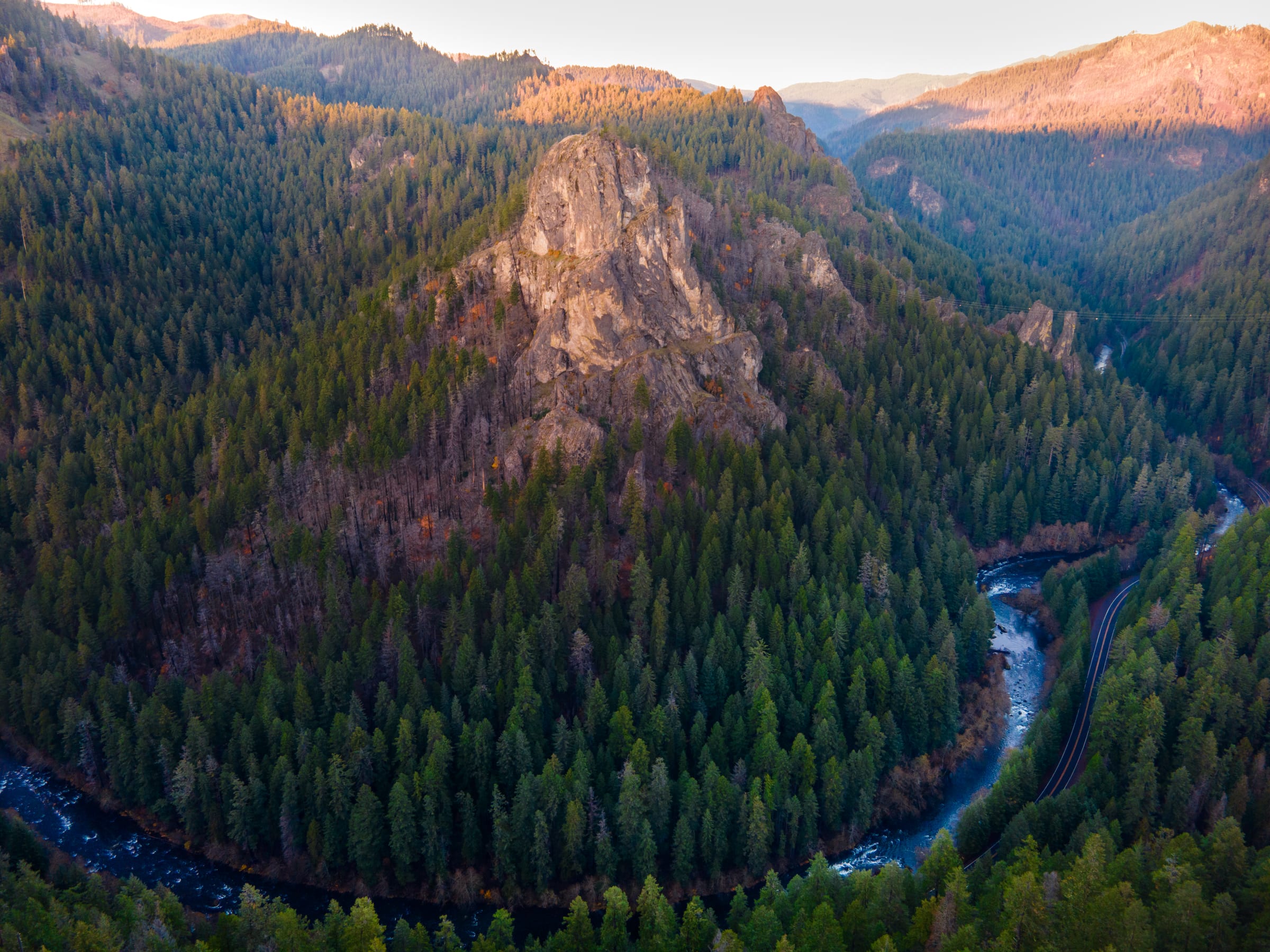 The North Umpqua River looping through a deep forested canyon under a bare rock face lit by low November sun