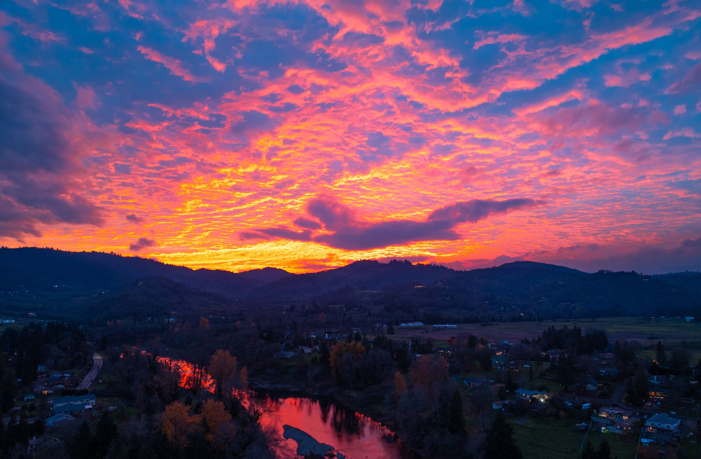 Pink and red December sunset clouds over the South Umpqua River as it runs through Roseburg